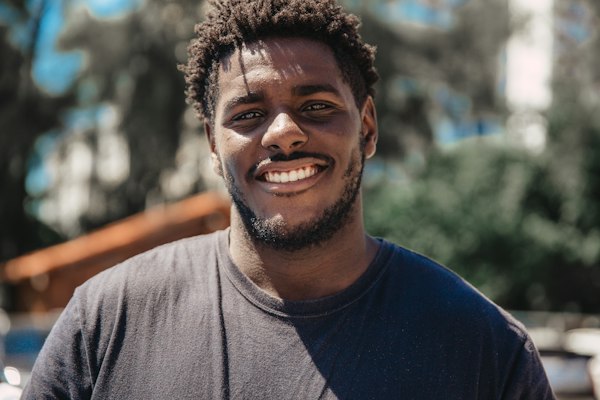 A young man in a gray T-shirt laughing